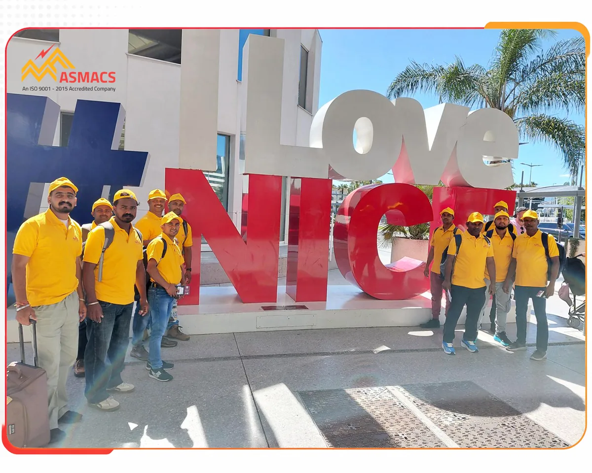 ASMACS skilled Indian professionals arriving in Nice, France at the I Love Nice landmark with luggage, June 2026